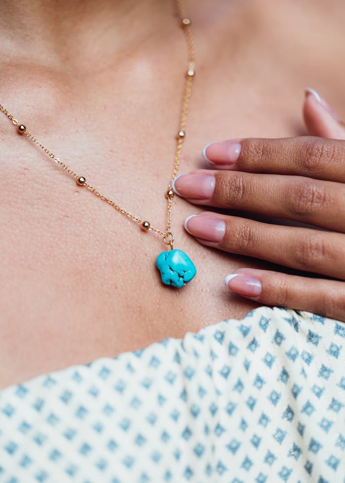 Elegant Turquoise Pendant Necklace on Patterned Dress